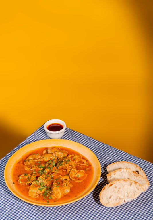 prato de moelas com tres fatias de pão e doce de malagueta malcriado em cima de uma mesa